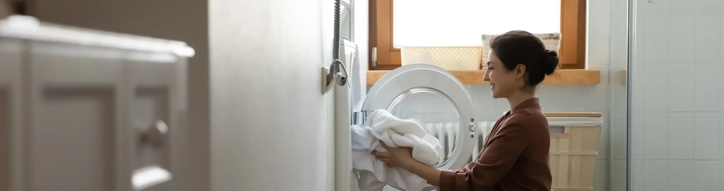 Woman loading laundry into a washing machine